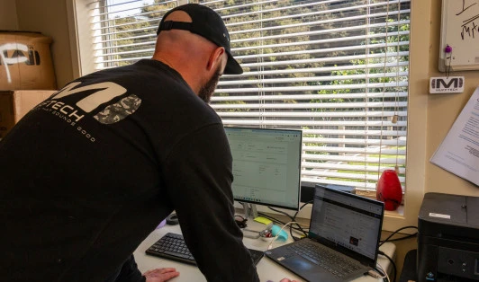 Man leaning at his desk in his home office using his computer