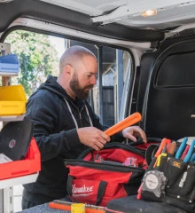 man sorts tools inside his van