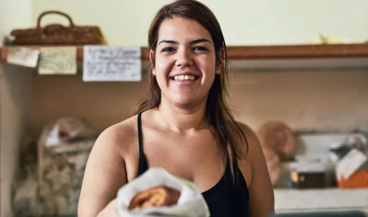 Woman handing pastry at a bakery