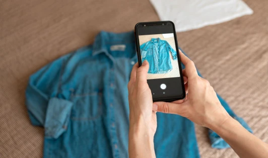 person taking a photo of a blue shirt