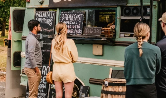 Customers stand around a food truck.