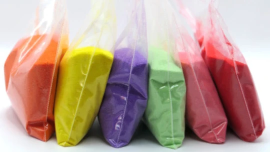 Plastic bags of multicoloured sand.