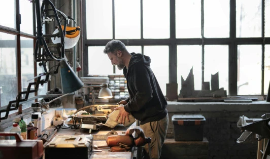 Person in a workshop working on a work bench.