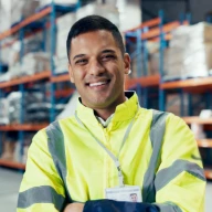 A worker in high-vis gear inside a warehouse.