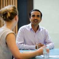 A man and a woman talking at a table.