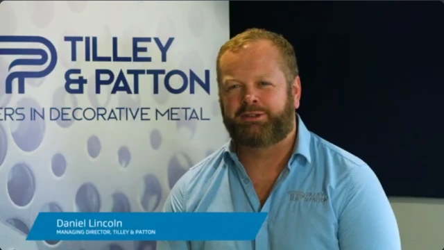 Man sitting in front of branded poster being interviewed